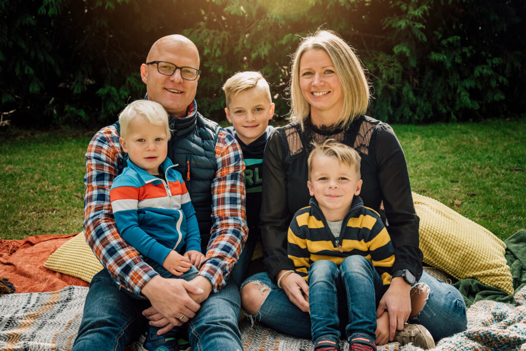Parents and children cuddling in layered outfits for a cozy fall family photo in Port Moody, BC