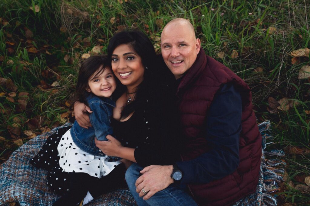 Family embracing in autumn park, dressed in earthy tones for a fall photography session in Greater Vancouver