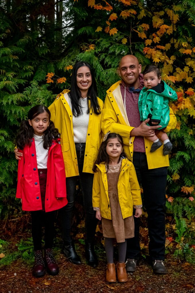 Siblings laughing together in fall outfits during a family photo session in the Lower Mainland