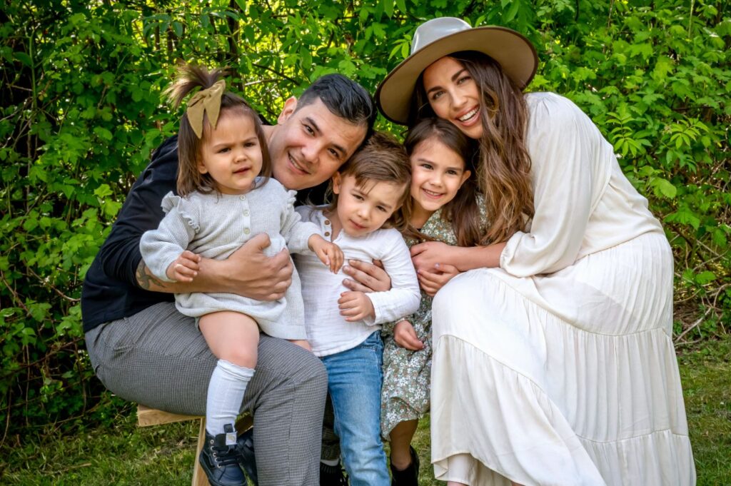 Family sitting together outdoors, wearing coordinated fall clothing for a photo session in Vancouver